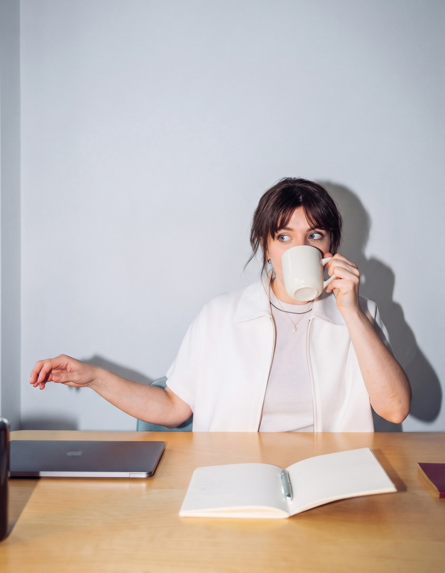 Ung entreprenör vid sitt skrivbord med kaffe och en anteckningsbok