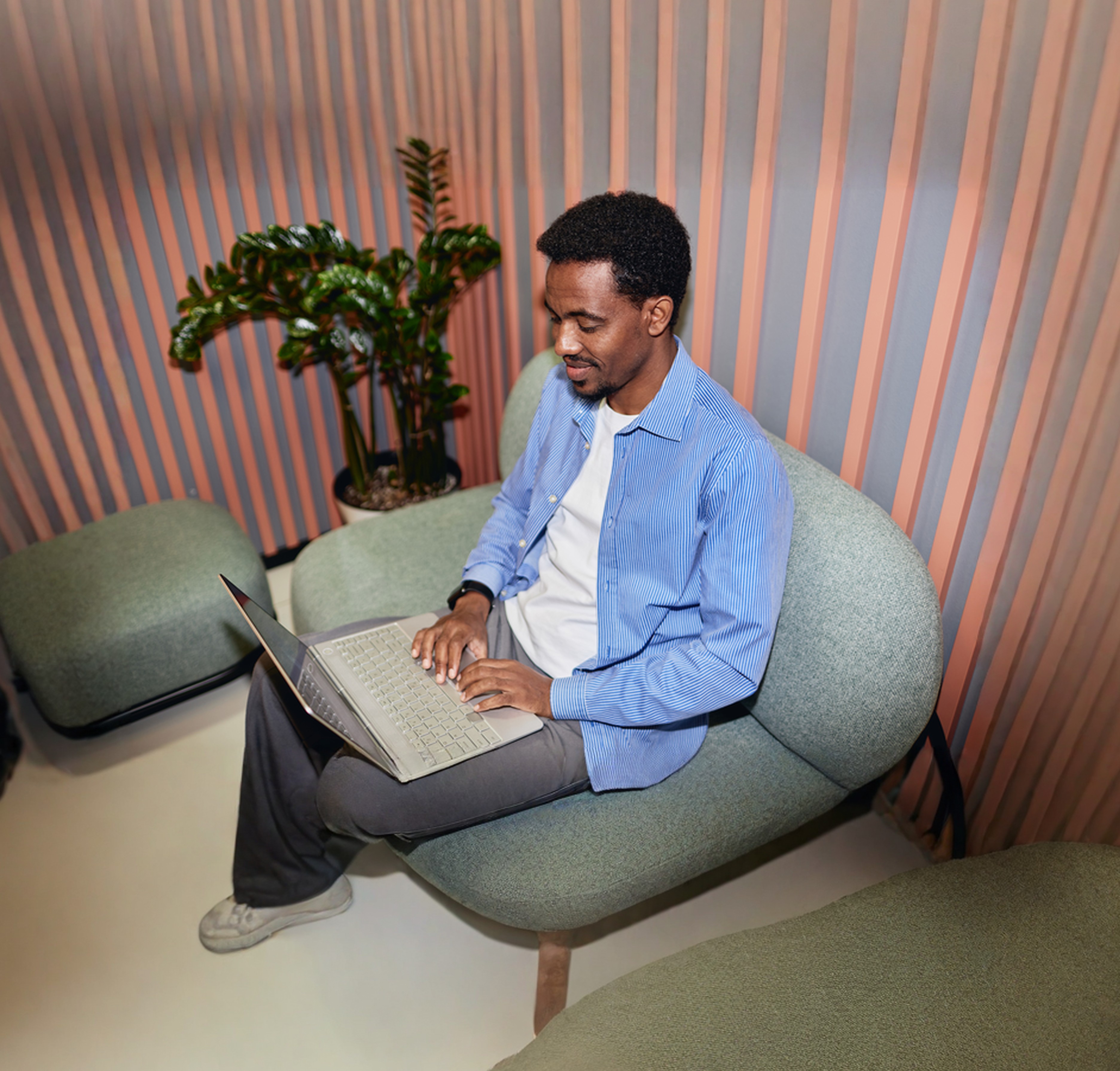 Person som arbetar på laptop i en avslappnad sittgrupp